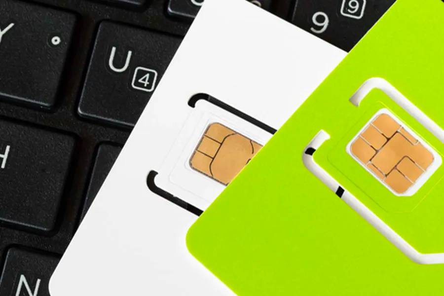 两张SIM卡靠在键盘旁，韩国留学生选择合适SIM卡的重要性展示。