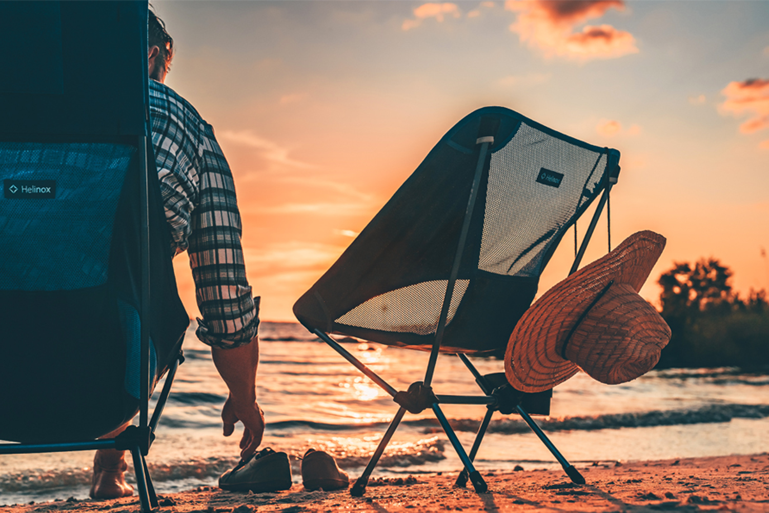 Khung cảnh cắm trại cùng sản phẩm của Helinox bên bờ biển lúc hoàng hôn, thương hiệu đồ cắm trại tiêu biểu.