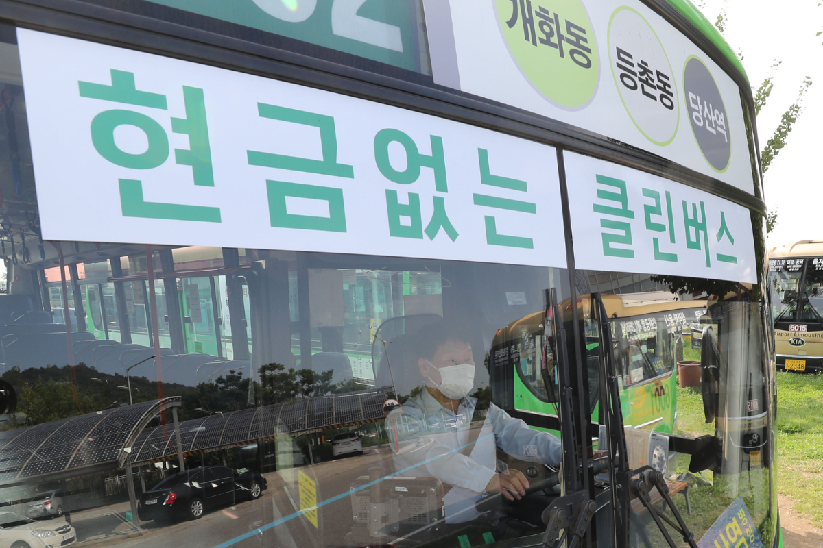 Bus di Korea dengan tanda yang menunjukkan bahwa bus tidak menerima uang tunai, menampilkan tulisan bahasa Korea di bagian depan.