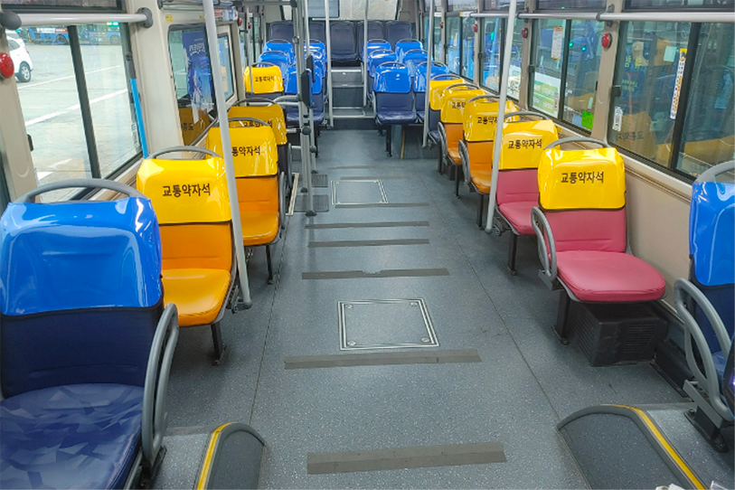 韓國公共巴士內部的座位配置，標示博愛座位置，提醒乘客禮讓需幫助的乘客。巴士內部座位色彩分明，便於乘客選擇合適的座位。