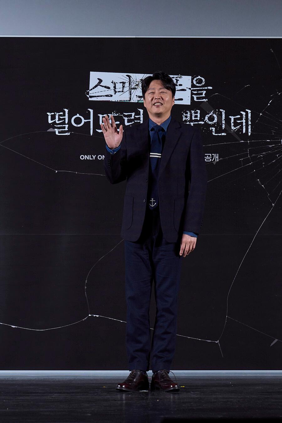 Netflix映画「スマホを落としただけなのに」の俳優キム・ヒウォンが製作報告会でポーズをとっている様子。映画のタイトルが背景に見えます。