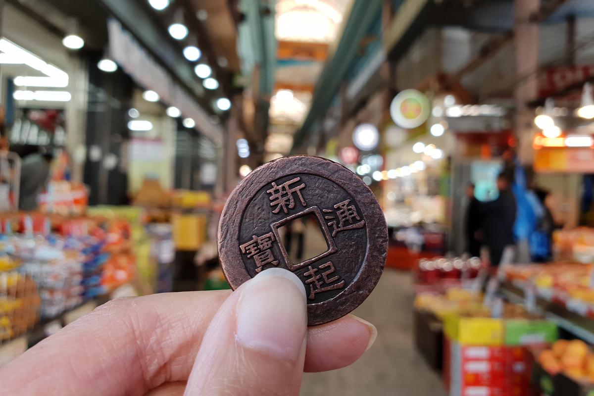 Large, cheerful cartoon figures at Singi Market inviting visitors to enter the shopping area filled with local products.