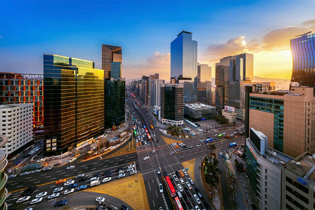 Veduta aerea del distretto di Gangnam a Seoul durante il tramonto, mostrando il traffico serale e i grattacieli contemporanei.
