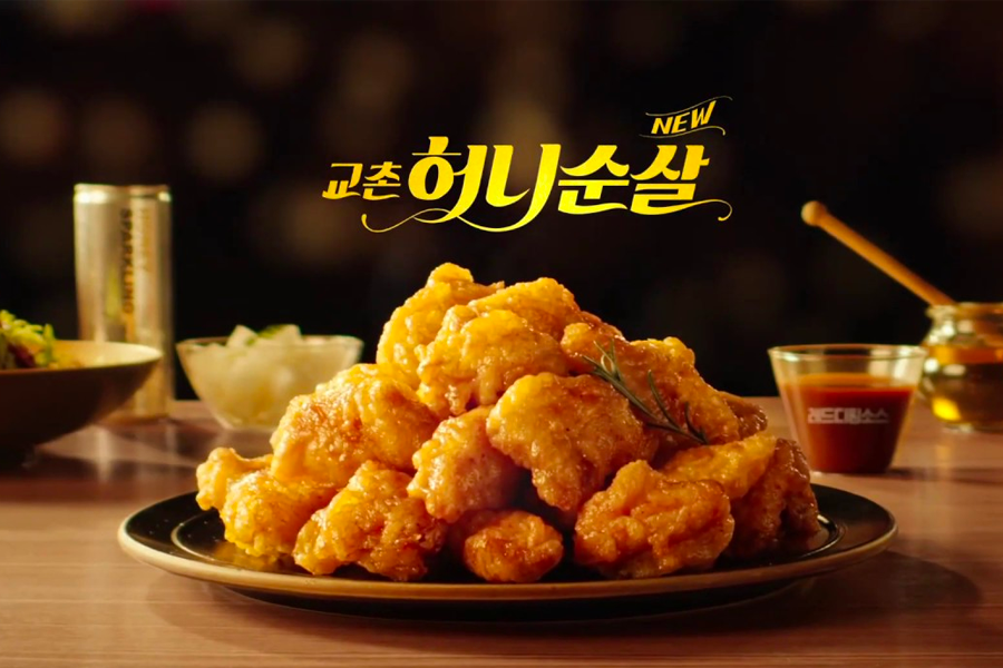 Sumptuous plate of honey-glazed Kyochon Fried Chicken tenderloin against a warm atmosphere in Jeju, South Korea.