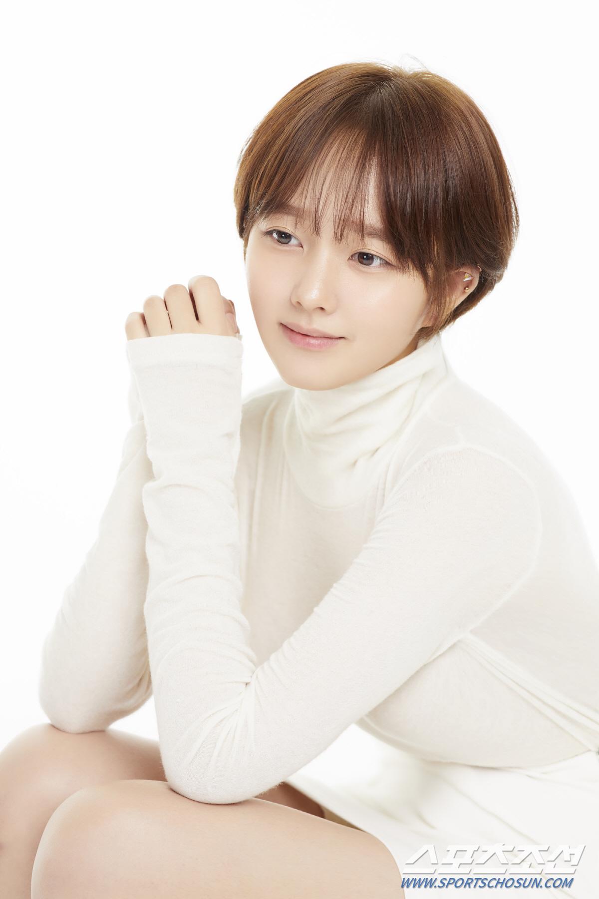 白い服を着た女性のイメージ。髪を肩までの長さにした短髪で、背景は白でシンプルです。