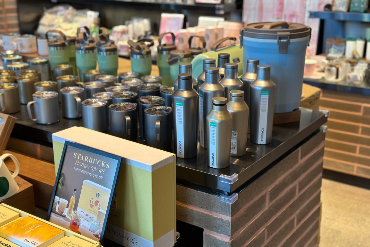 Дисплей продукции Starbucks с термосами и кружками в филиале Букхансан