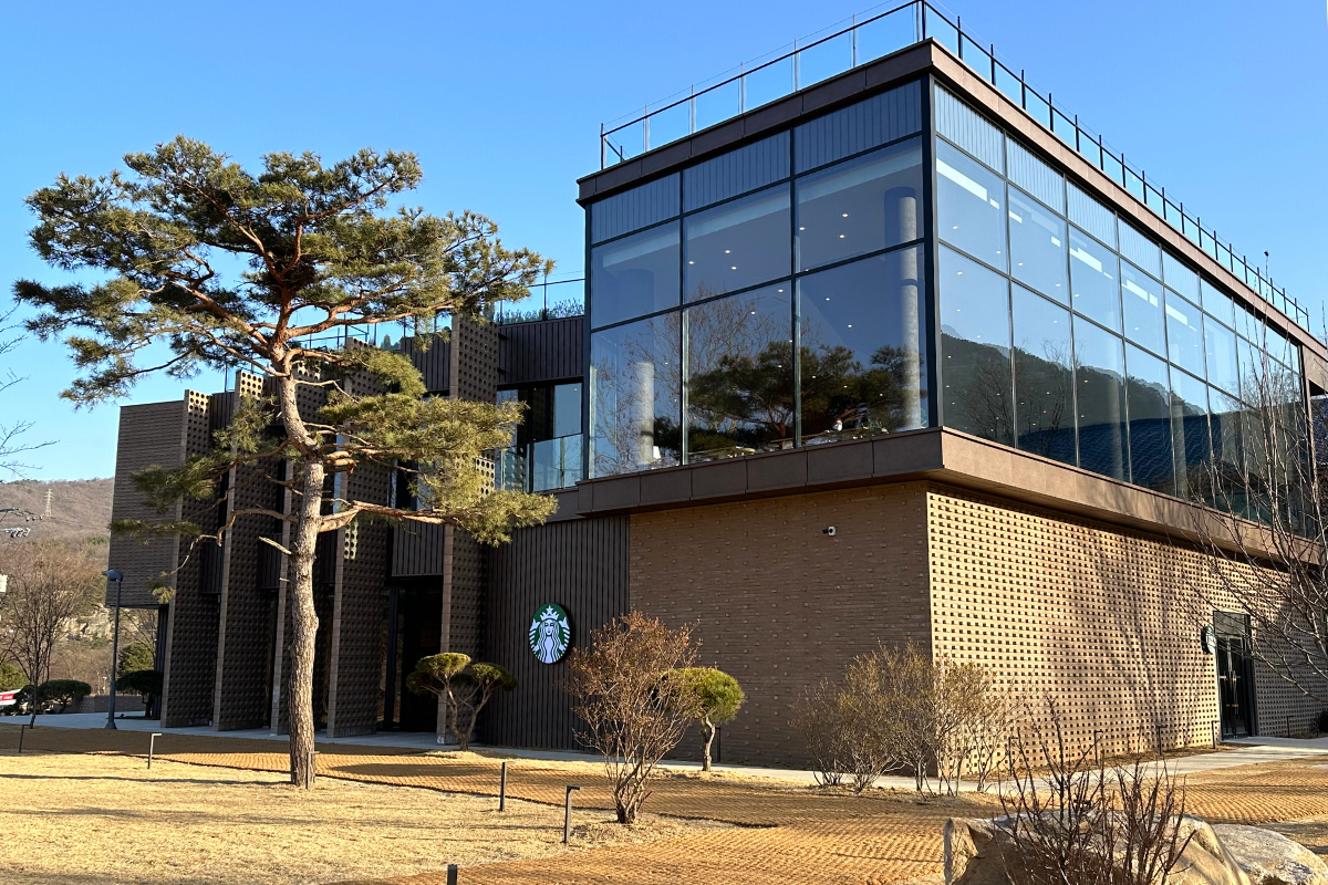 Внешний вид Starbucks THE Bukhansan с сосной на переднем плане