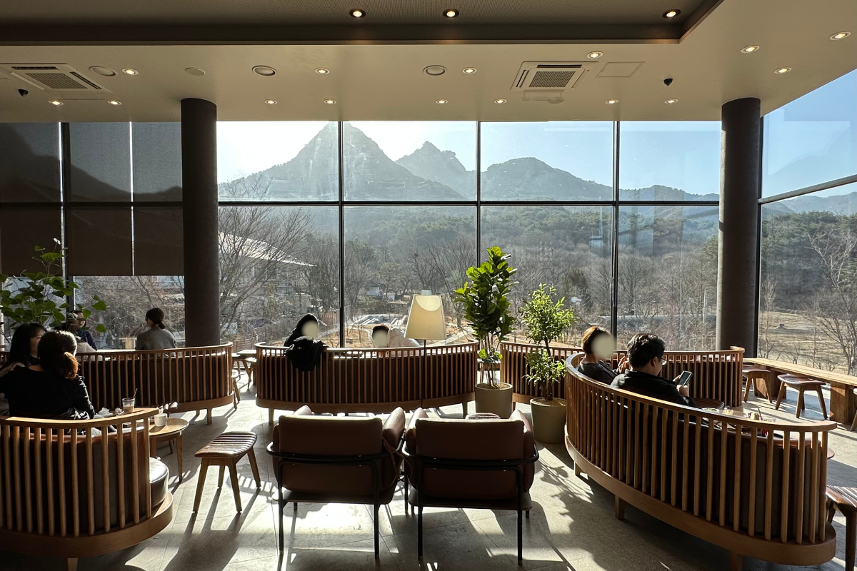 Интерьер второго этажа Starbucks THE Bukhansan, оформленный в теплых тонах с понятием природы