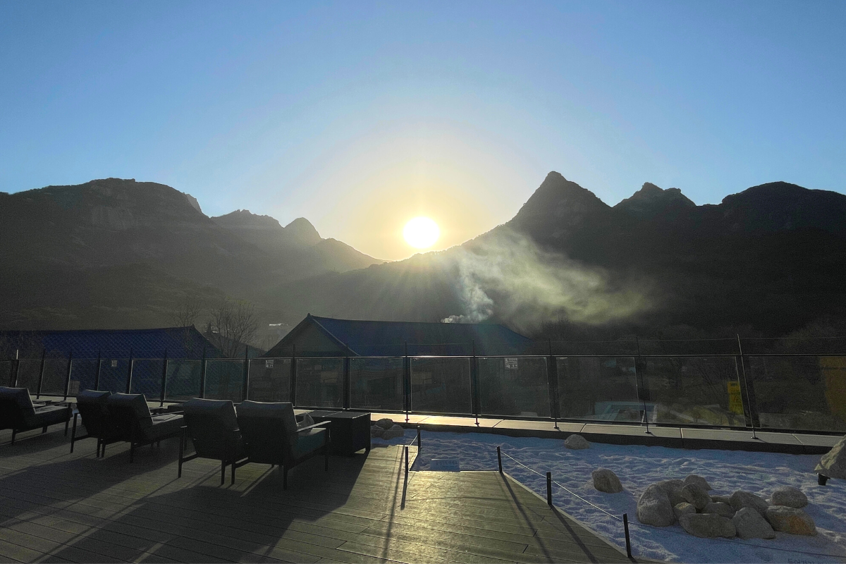 Sunrise over Bukhan Mountains as seen from the rooftop terrace of Starbucks THE Bukhansan in Seoul, South Korea, casting a serene light over the landscape.