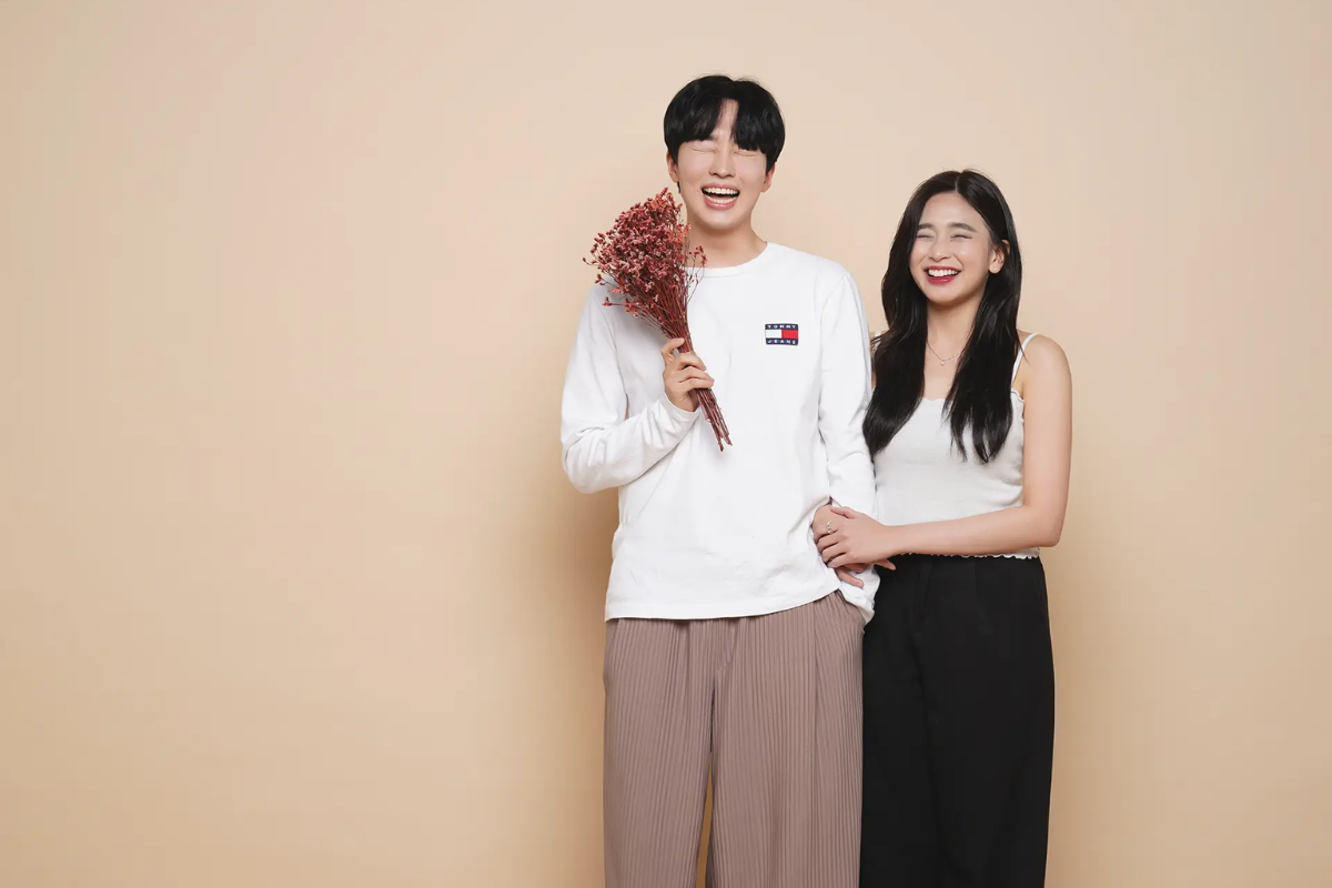 Couple in a Korean photo studio with stylish outfits, capturing memories in studio quality.