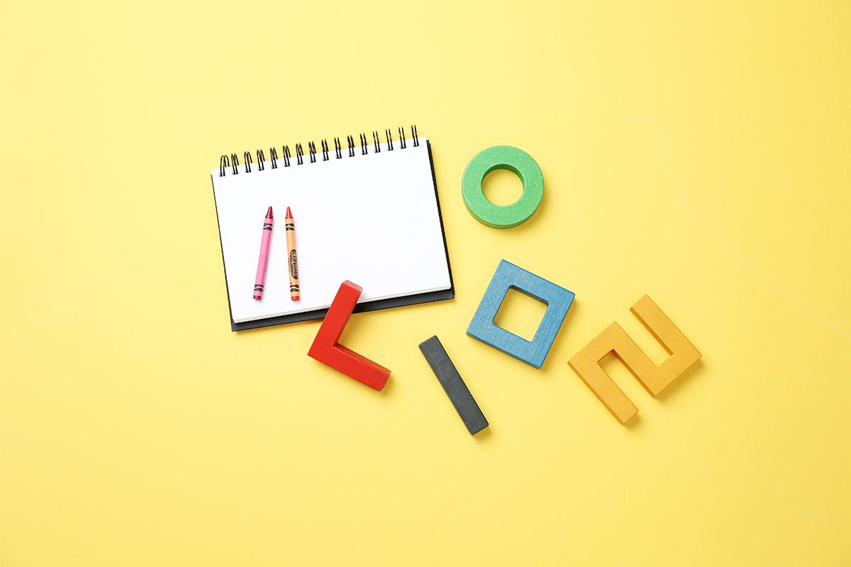 Ein Notizbuch und bunte geometrische Blöcke, die das kreative Lernen darstellen.