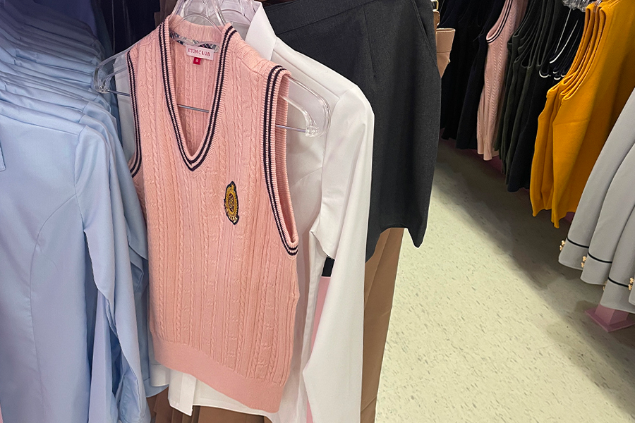 강남교복 대여점에서 제공하는 여성용 핑크색 조끼와 교복 셔츠 사진.