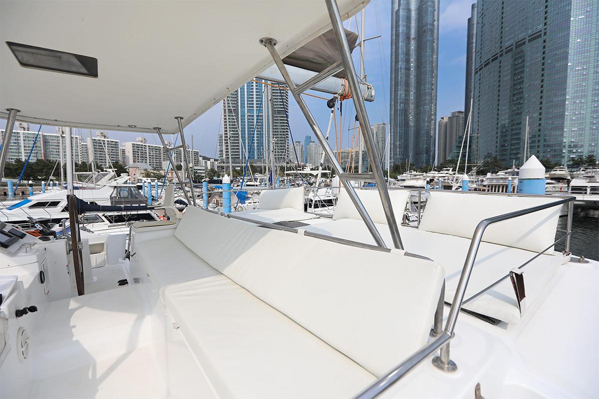 Open yacht seating area with buildings and marine surroundings in Busan, South Korea.