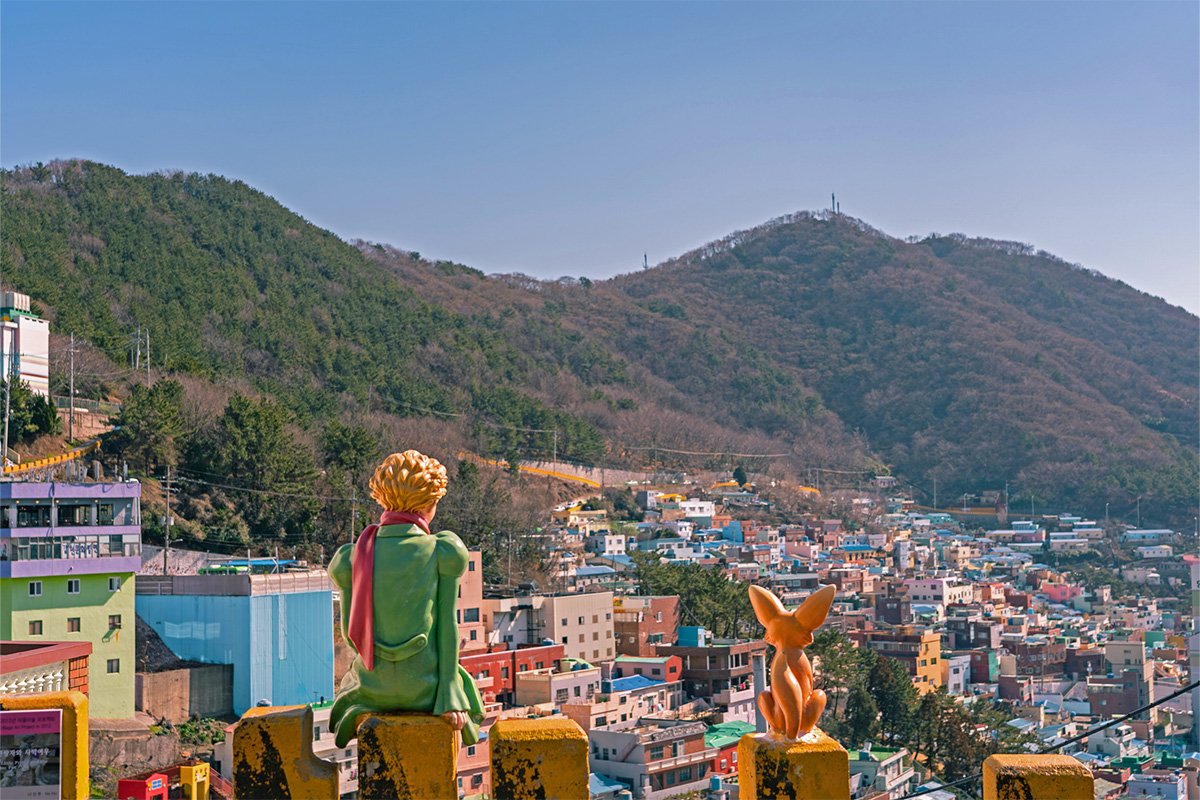 Iconic statue of the Little Prince and the fox overlooking the vibrant Gamcheon Culture Village.