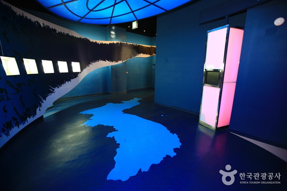 Innenraum des Cheorwon Peace Observatory mit einer Karte der koreanischen Halbinsel auf dem Boden und Ausstellungsstücken.