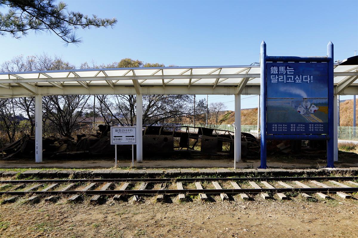 Verrosteter Zug an der Woljeongri-Station, symbolisierend die Teilung Koreas, mit einer Informationstafel.