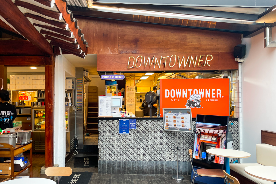 韩国Downtowner汉堡店的室内照片，展示店内设计和就餐区的布置，木质内饰和美食菜单。