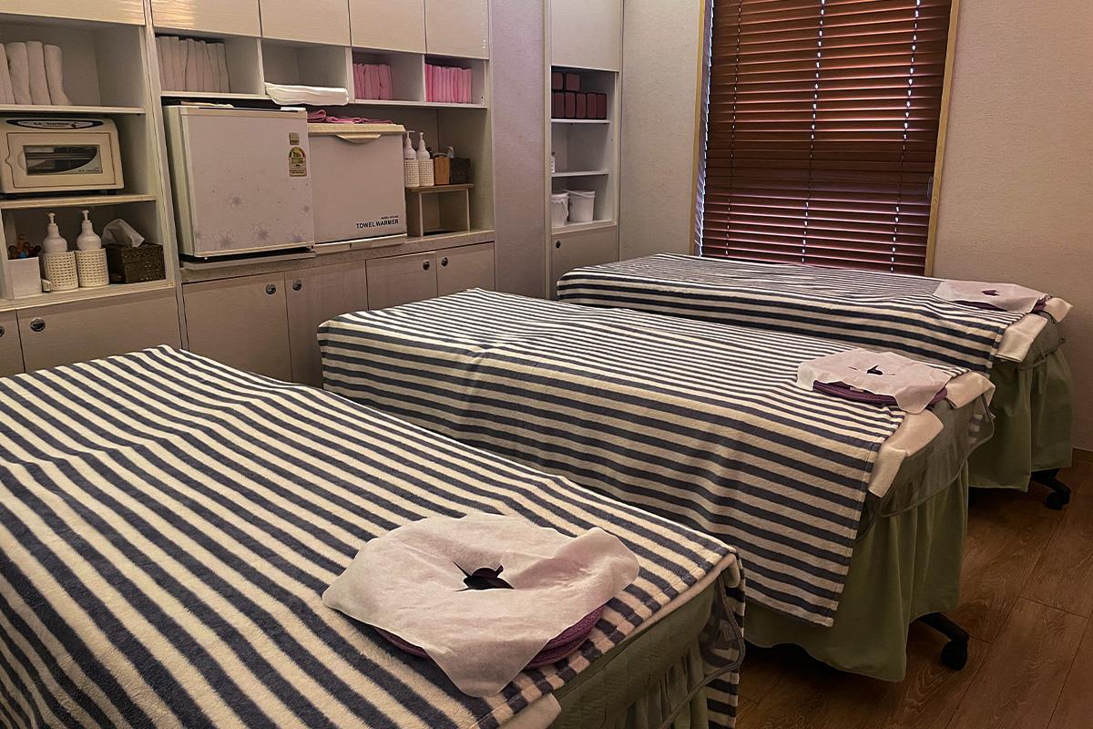 Fully equipped spa room with massage beds and warm lighting at Happy Skin Myeongdong Spa.
