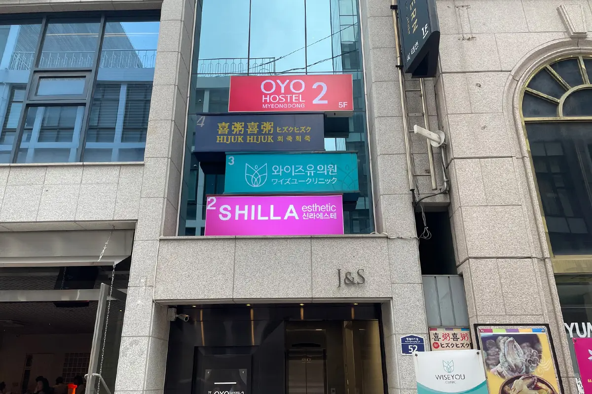 SHILLAエステのビル外観を示す写真で、施設への入り口には看板が掲げられています。