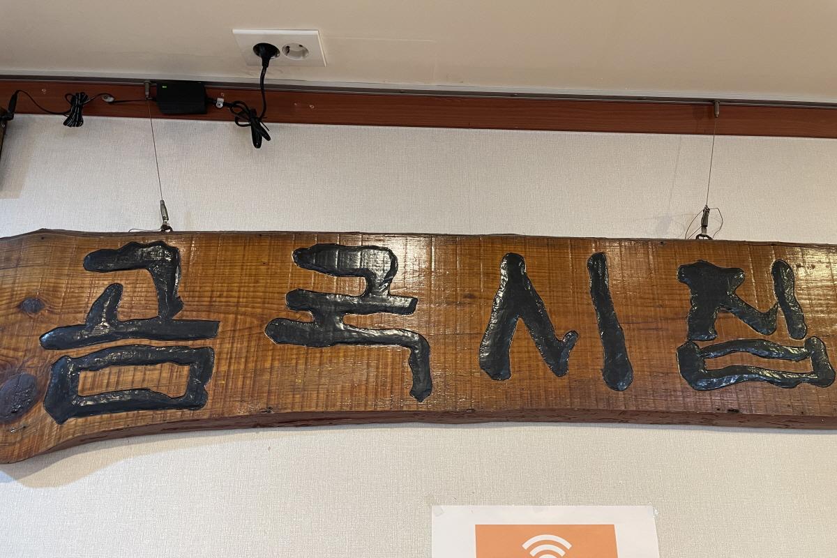 在墙上挂着的是牛骨汤之家店名的木制牌匾，展示店家的传统风格。