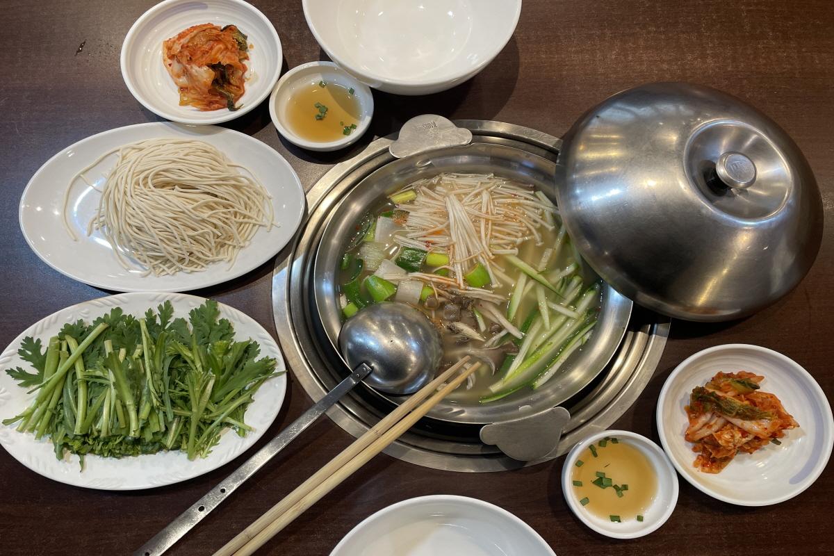 一锅可口的牛骨汤配料显示韩国牛骨汤之家的特色菜肴。