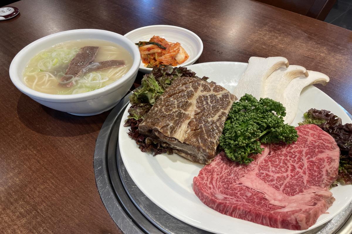 韩国牛肉搭配牛骨汤面和泡菜，展示Creatrip与牛骨汤之家合作的菜单。