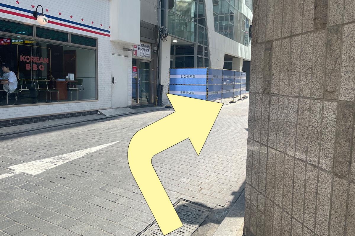 指示在巷子口右转的黄色箭头，帮助找到从地铁到店铺的路线