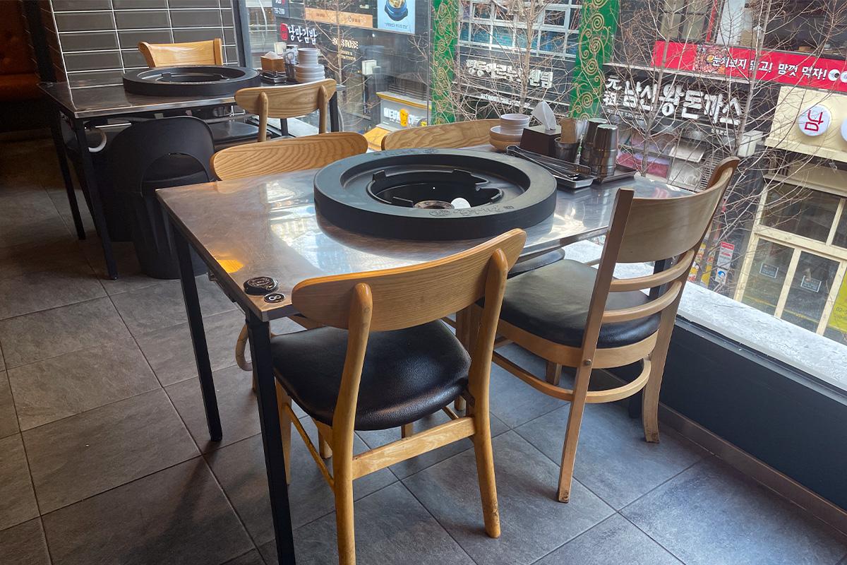 位于韩国明洞烤肉店的窗边座位，可以一边享用美食一边眺望外面的街景，体验独特的用餐氛围