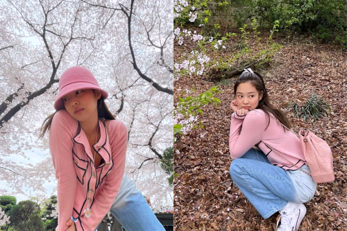 Woman wearing a pink hat and cardigan standing under vibrant cherry blossoms, capturing the spring essence in Korea.
