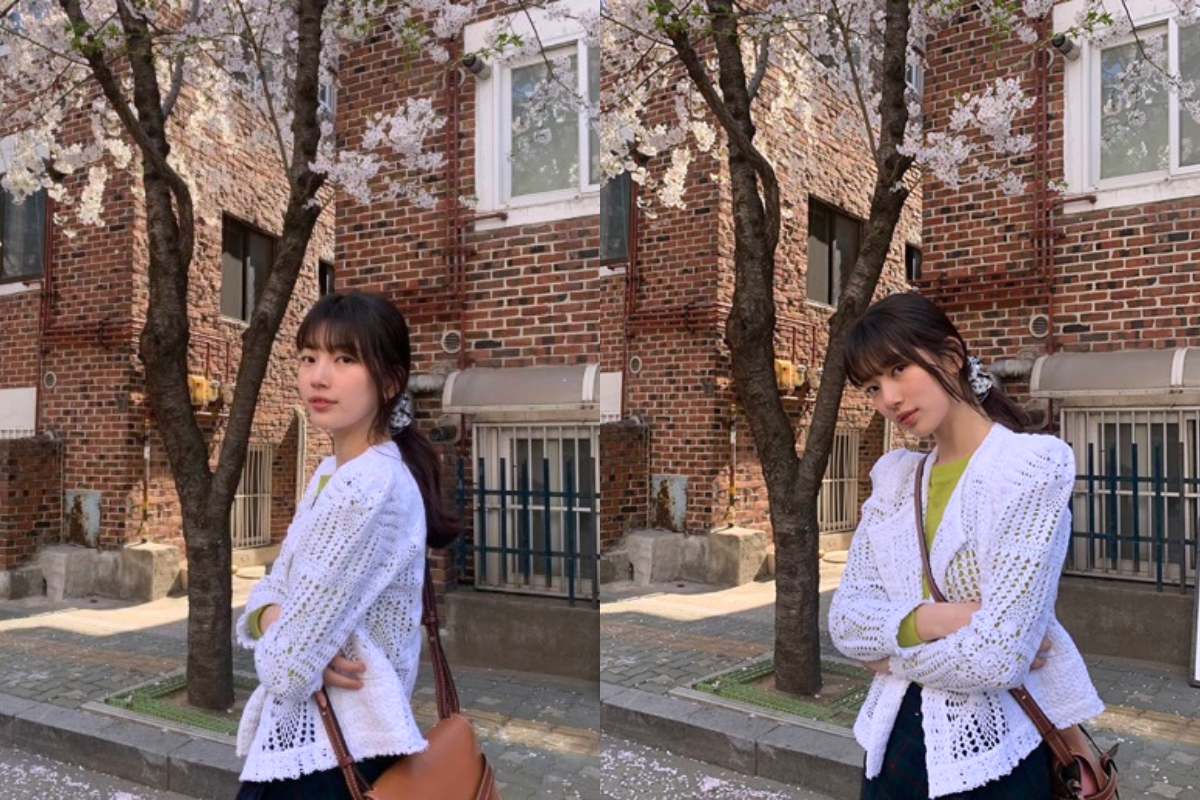 Bae Suzy posing under cherry blossoms, showcasing effortless style and the beauty of springtime in Korea.