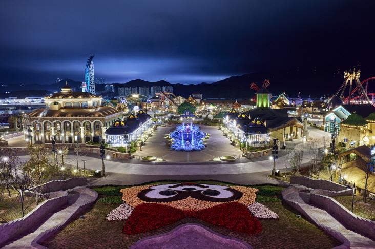 Vue nocturne du Lotte World à Busan avec ses installations lumineuses et attractions thématiques.