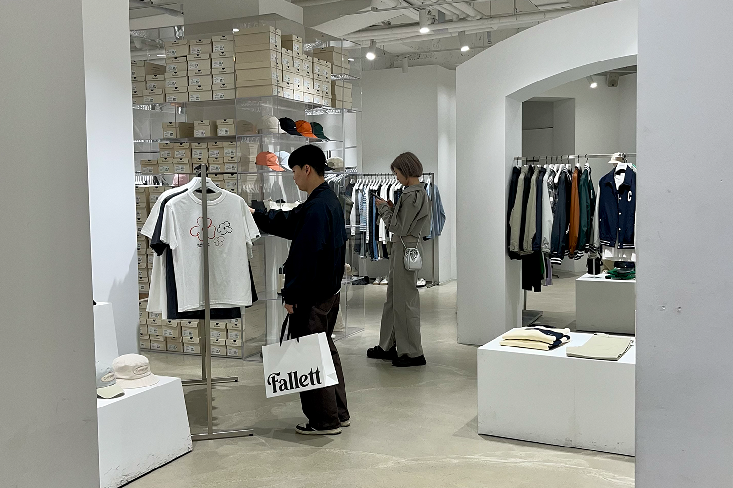 Covernat店內展示區，擺放著各式春夏新品，如短袖T恤、風衣和外套。