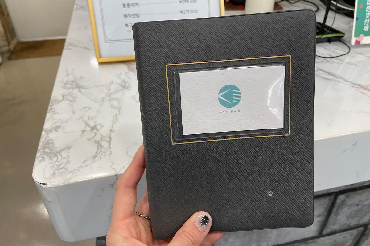 หนังสือรายการราคาบริการและเมนูในร้าน RAVI HAIR ที่วางตรงโต๊ะลูกค้า