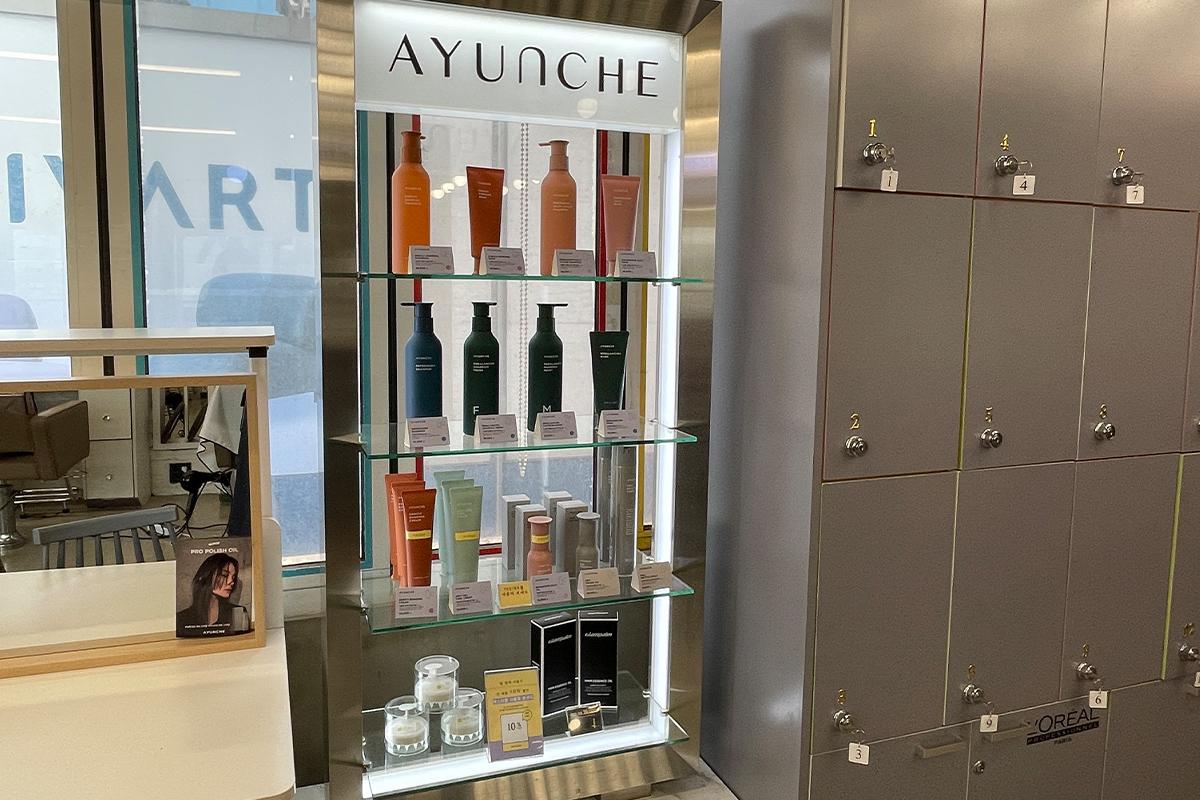ชั้นวางผลิตภัณฑ์ Ayunche โชว์หลากหลายผลิตภัณฑ์ดูแลผมภายในร้าน RAVI HAIR