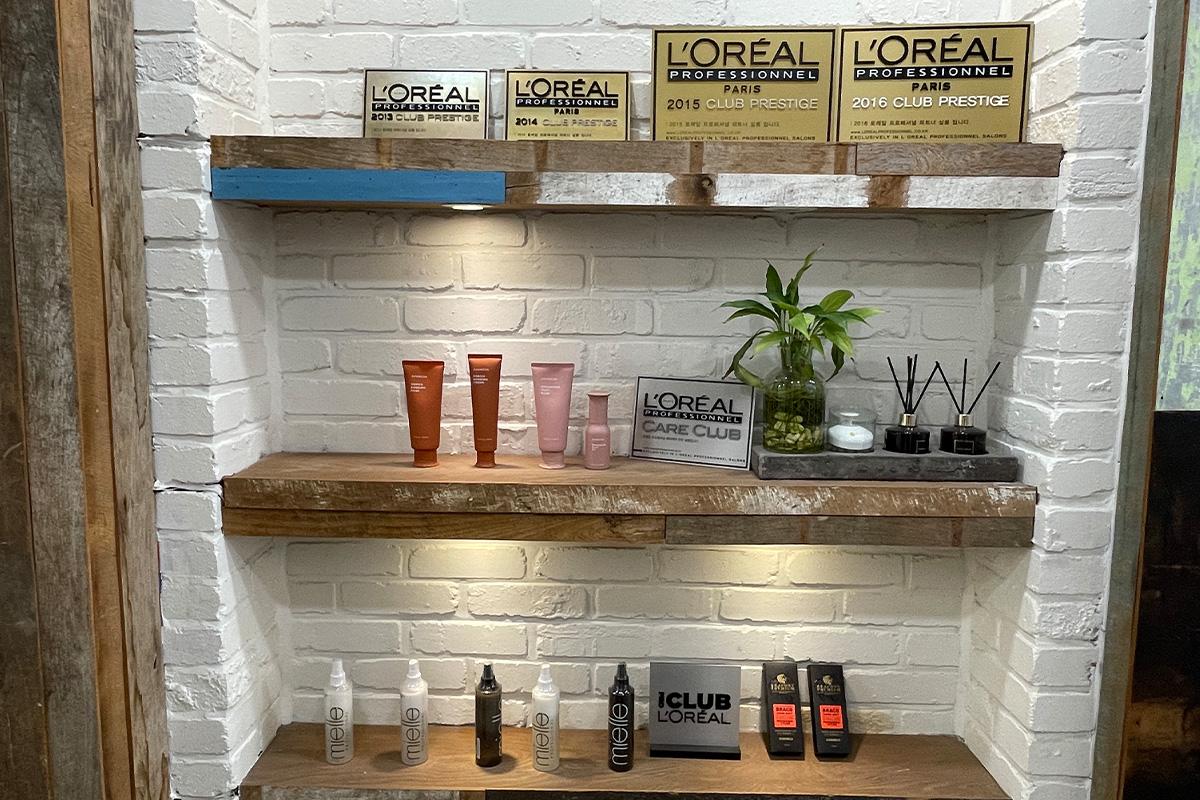 ผลิตภัณฑ์บำรุงผมและโล่รางวัลในชั้นตกแต่งภายในร้าน RAVI HAIR