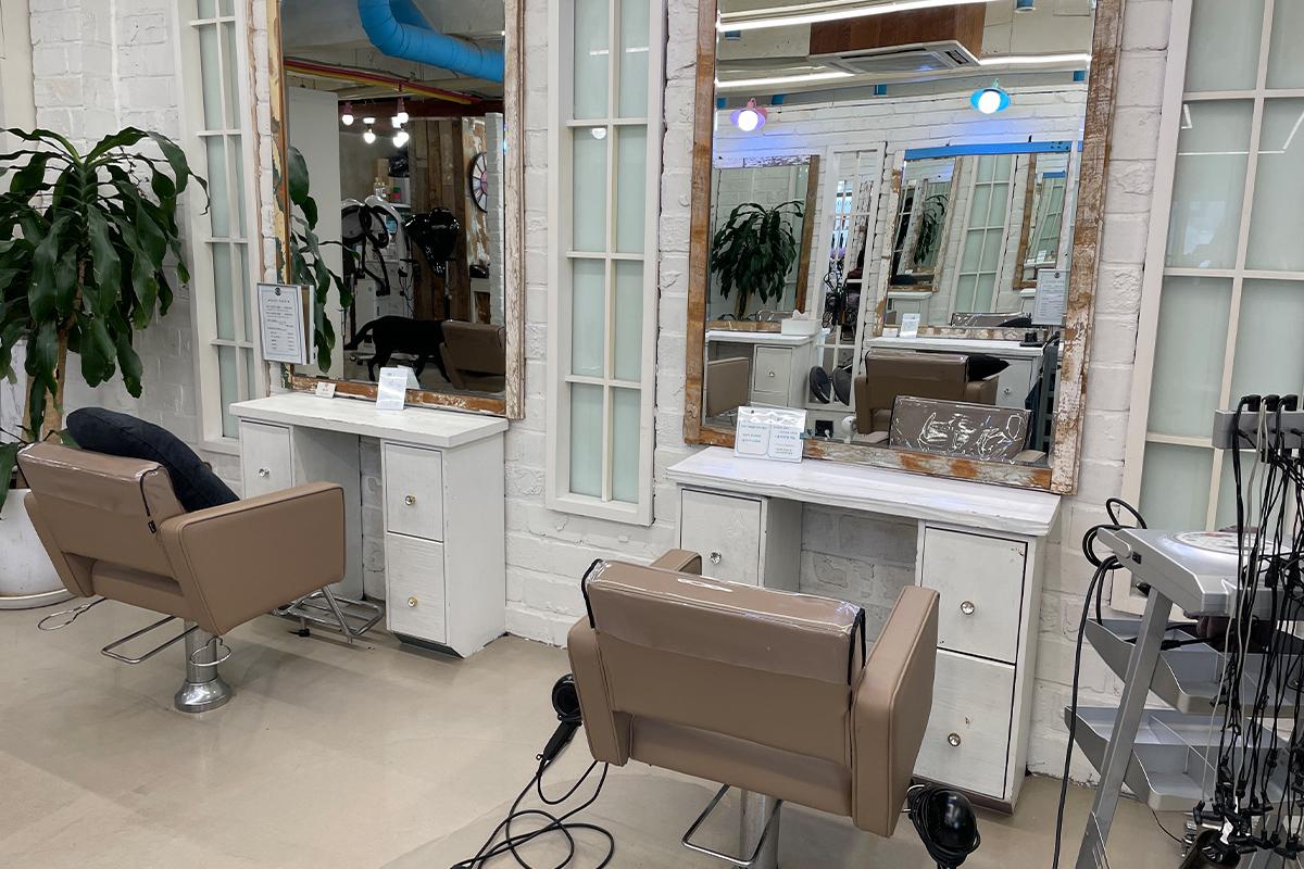 โต๊ะทำงานและโต๊ะสำหรับลูกค้าที่ RAVI HAIR ฮับย็อง มองเห็นวิวถนนภายนอก