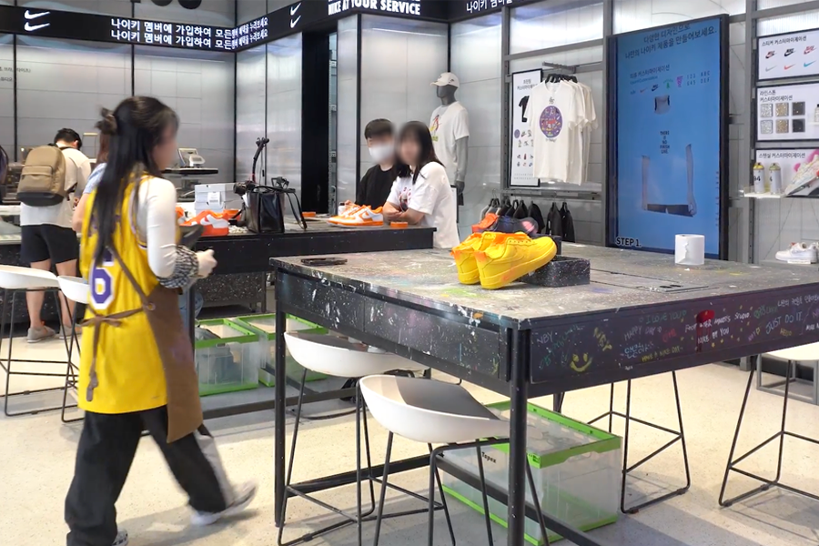 Interior of Nike's customization area with customers engaging in design activities