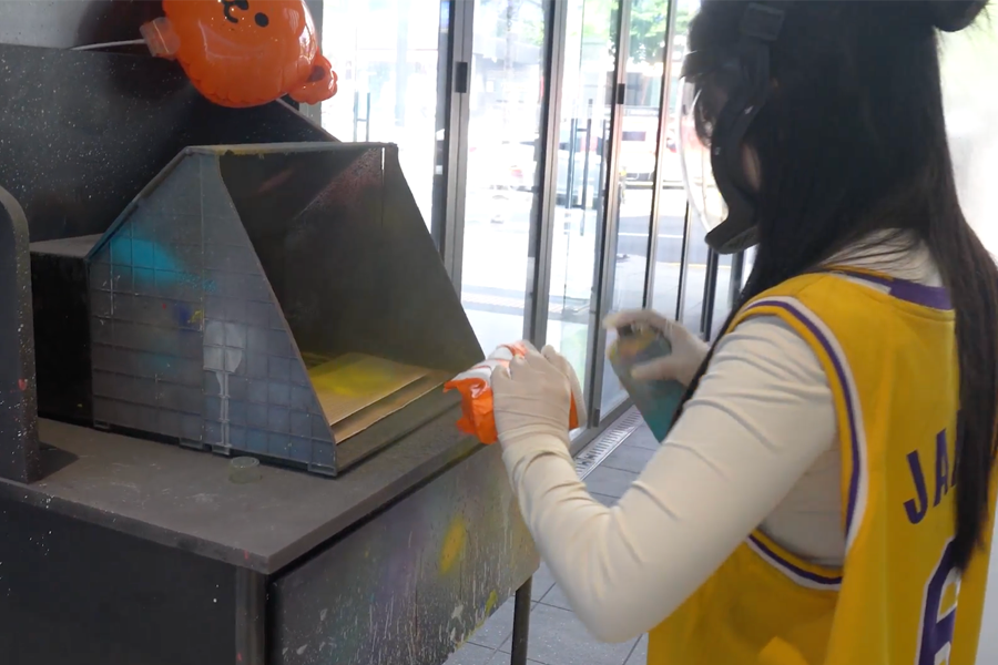 Nike employee at Apgujeong applying spray paint to customize sneakers