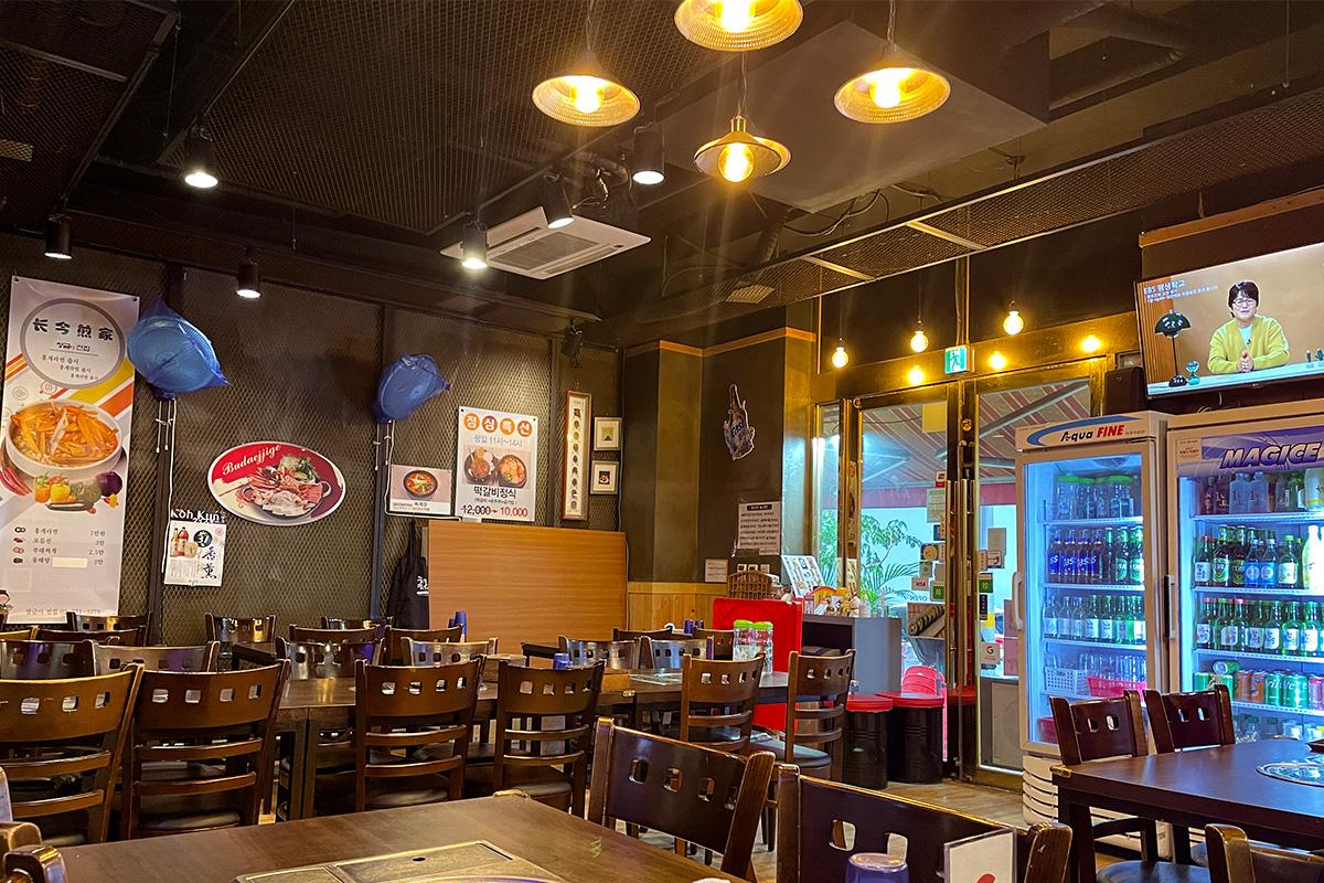 明洞长今煎家的室内环境，展示韩国传统装饰和美食海报。