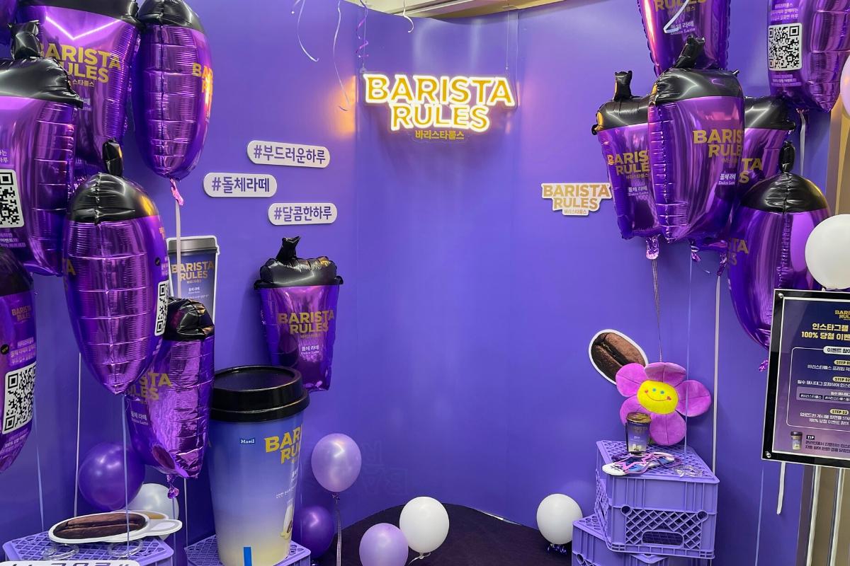 Purple-themed Haru Film photo booth interior with Barista Rules branded balloons and neon sign.