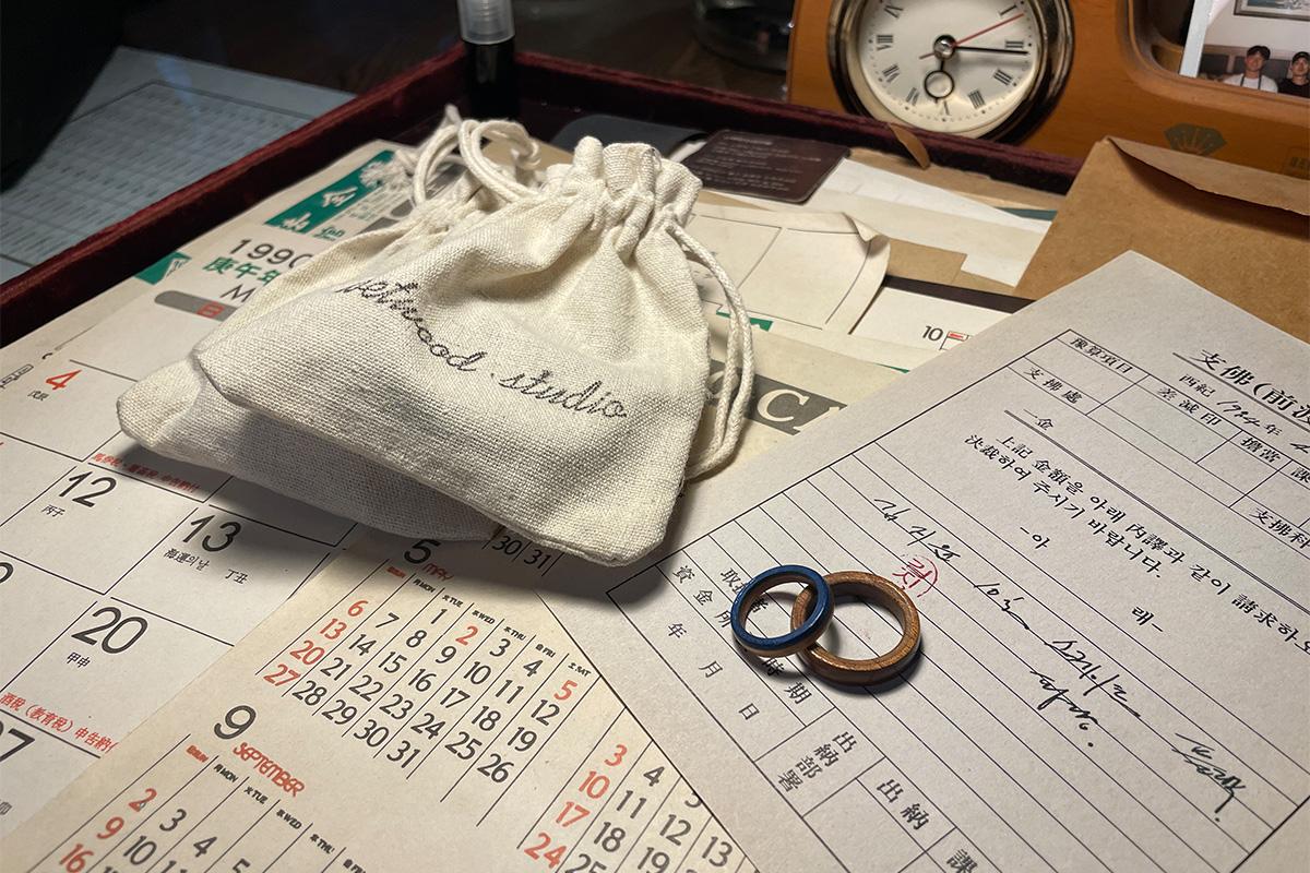 套在手指上的手工制木戒指，展示在Wetwood Studio 的木质纹理与精湛的圆润造型。