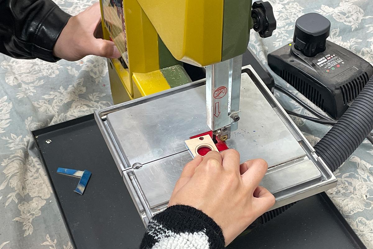 Wetwood Studio 顾客在切割木材，使用精密切割机依据设计图形将多余部分裁去。