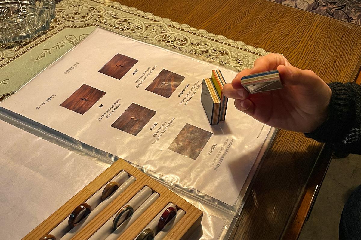 Wetwood Studio 中展示的木材样品，顾客正在选用用于木戒指制作的滑板材料块。