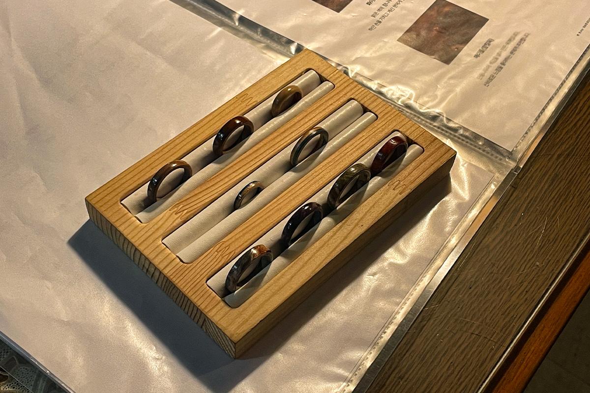 展示在Wetwood Studio 中的成品木戒指，排列整齐在木制展示架上供顾客欣赏。