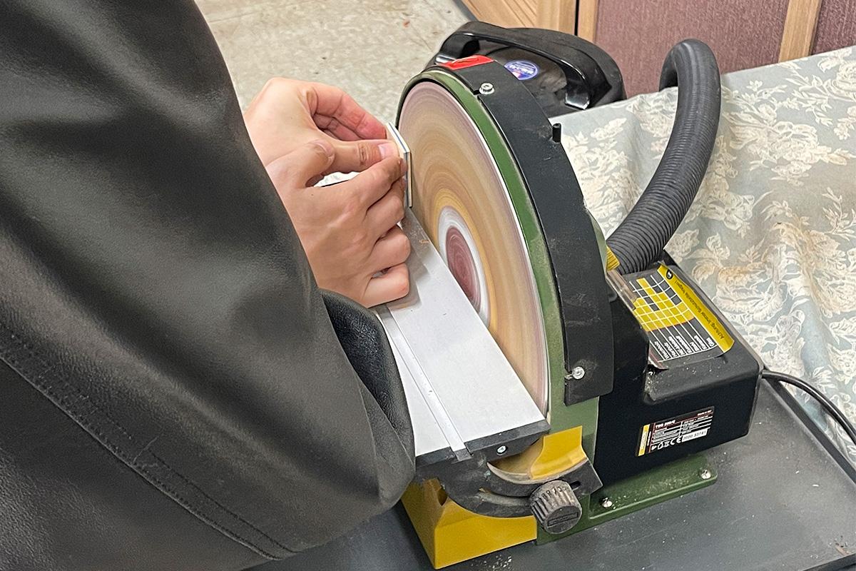 顾客在Wetwood Studio 利用砂轮机将选定好的木材磨平，为后续木戒指的制作做好准备。