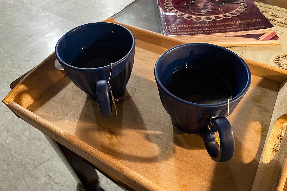 在Wetwood Studio 提供的饮品服务中，两杯浓香的红茶用蓝色陶瓷杯呈现，摆放在托盘上。