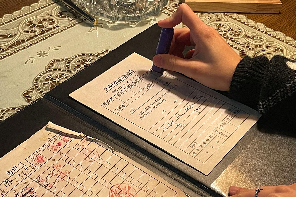 Wetwood Studio 内顾客将独特个性印章盖在复古文件上，为木戒指DIY体验增添风味。