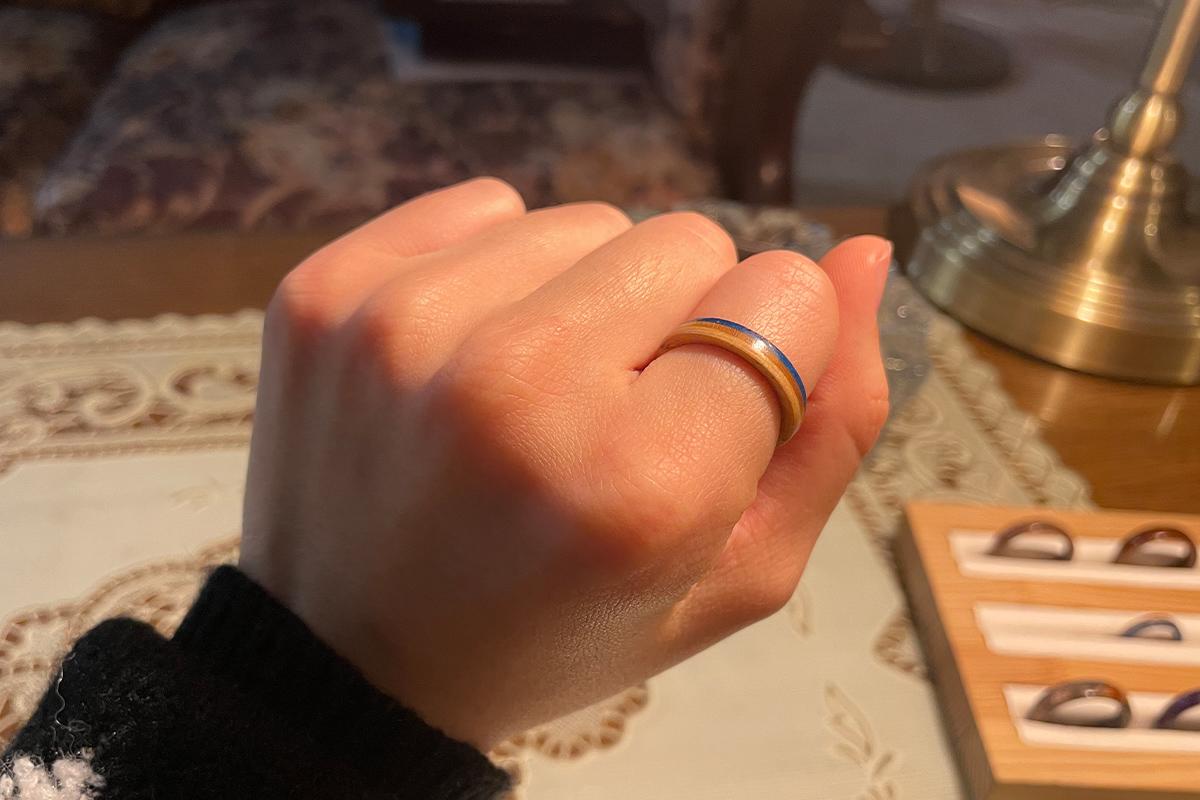 Wetwood Studio 顾客手中展示刚质完成的木戒指，细致的工艺和色彩展现清晰可见。