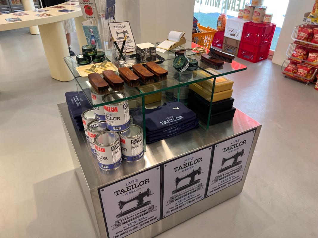 NCT CCOMAZ GROCERY STOREのキャラクターをテーマにしたグッズ展示。カラフルなアイテムが並ぶ。