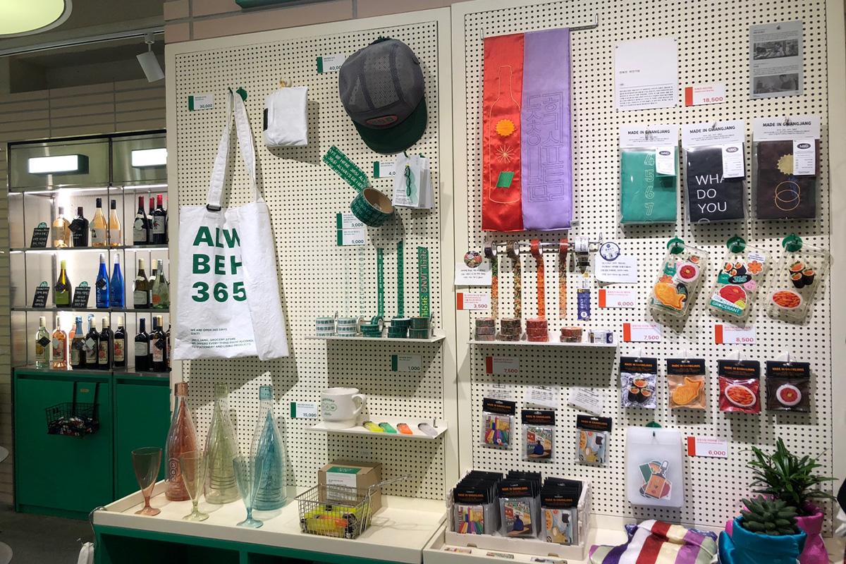 Rak toko di Pasar Gwangjang yang menampilkan berbagai barang seperti minuman dan tas.